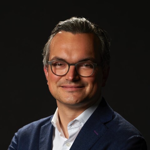 Portrait of venture capital investor Christian Teichmann, Burda Principal Investments, in front of a black studio background.