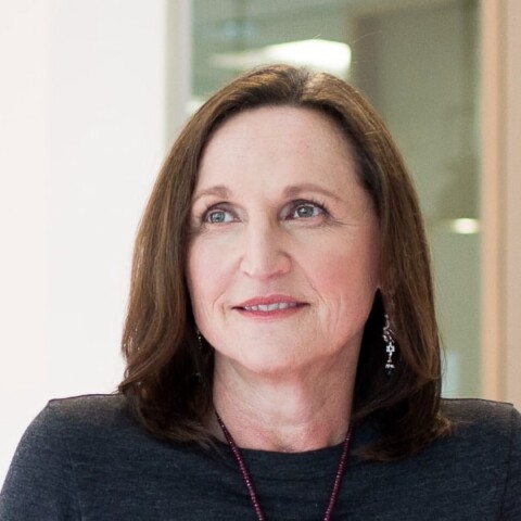 Environmental headshot portrait of Silicon Valley marketing expert Margit Wennmachers (a16z), looking up, standing in front of a glass door.