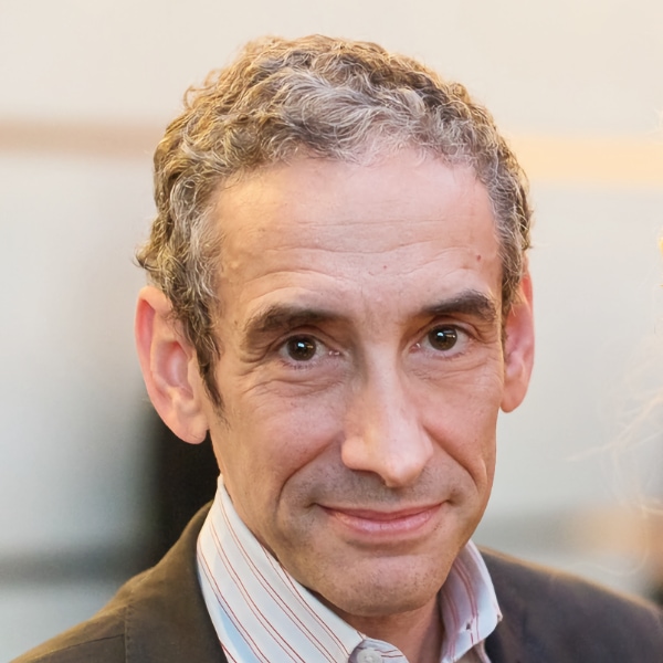 Headshot portrait of author and Professor Douglas Rushkoff, smiling at the camera.