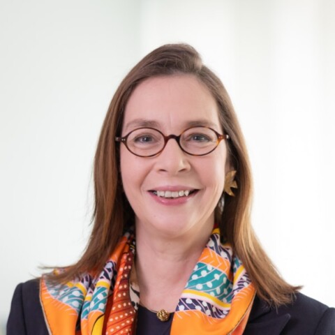Portrait of E.ON board member Victoria Ossadnik, wearing a colorful scarf, smiling at the camera.