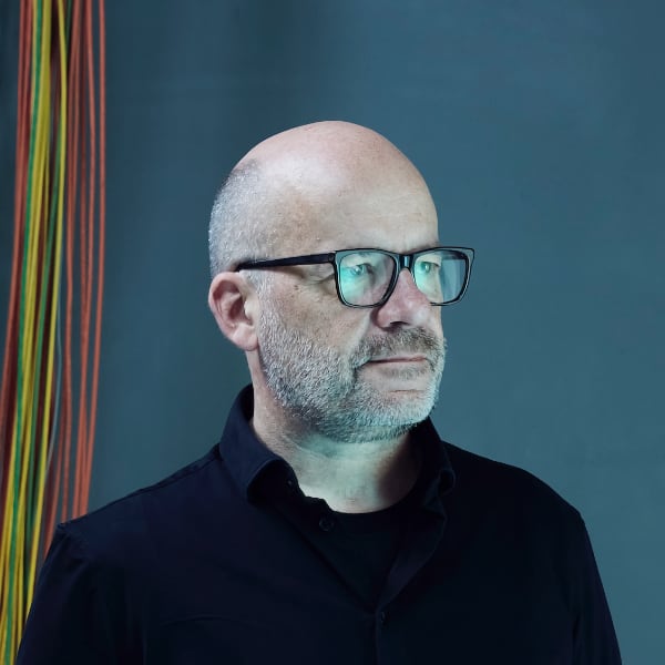 Portrait image of Rafael Laguna de la Vera, Director SPRIND, Germany’s Federal Agency for Disruptive Innovation, in front of a blue studio background.