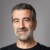 Studio headshot portrait of former SpaceX manager Bulent Altan, Alpine Space Ventures, in front of a grey background, smiling at the camera.