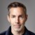 Close-up portrait of Joram Voelklein, Founding Partner of Alpine Space Ventures, in front of a grey studio background.