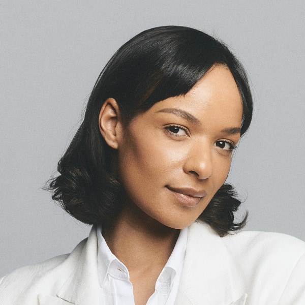 Studio ortrait of investor Judith Dada, Visionaries Club, in front of a neutral grey background.