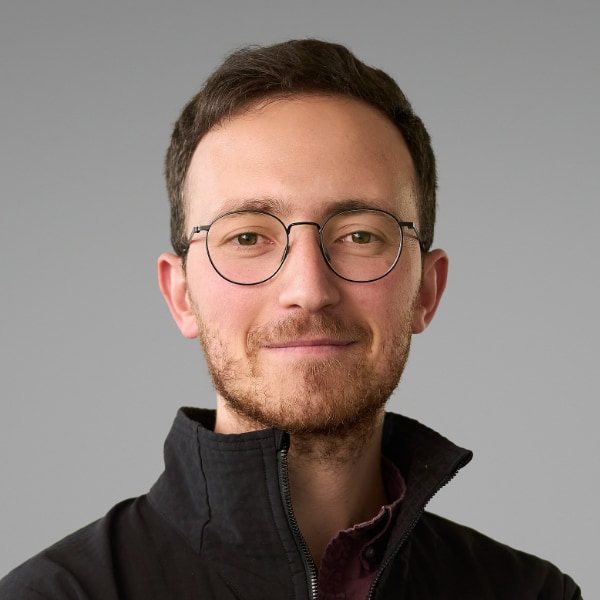 Studio portrait of Francesco Sciortino, Co-Founder & CEO of cleantech startup Proxima Fusion, in front of a grey background.