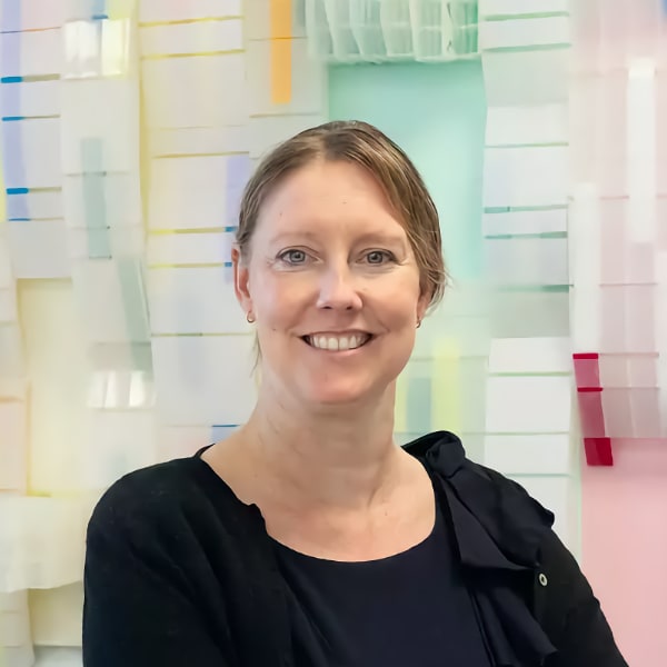 Portrait of Jennifer Rupp, Professor for Electrochemical Materials at TU Munich, in front of a colorful background.