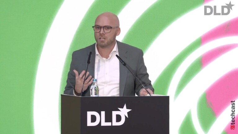 Fabian Mehring, the Bavarian State Minister for Digital Affairs, on stage at the DLD Munich 2024 conference. Visible behind him is the colorful conference design in green and pink.