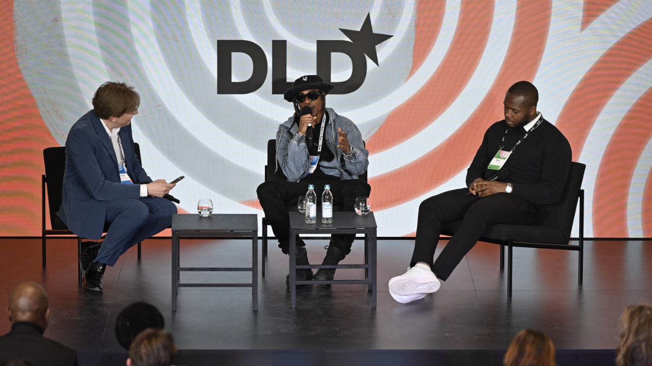 Nigerian pop star 1da Banton speaks at the DLD Munich 2024 conference, with Thomas Hesse (Dreamstage) and his manager Bryan Owujie listening.