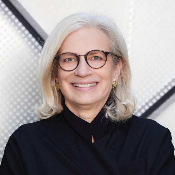 Headshot of German architect Andrea Gebhard in front of a metallic looking background.