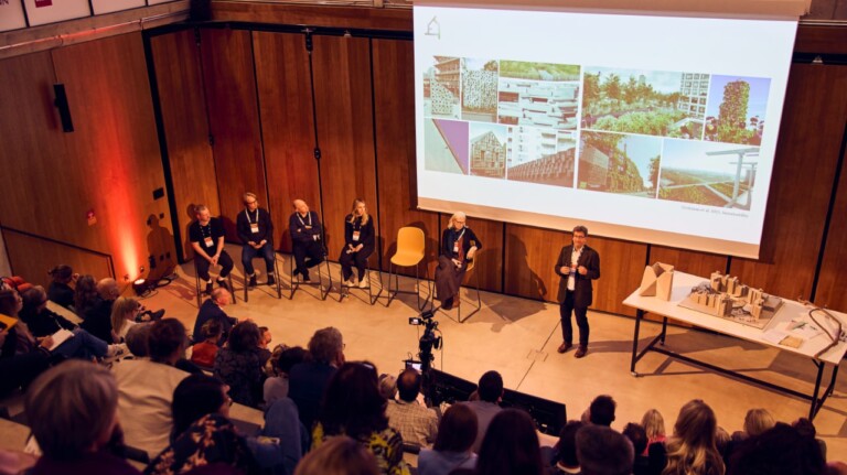 Full auditorium at the Munich Urban Colab, where Thomas Hauck, Sebastian Koth, Werner Lang, Ferdinand Ludwig, Marlene Stechl and Wolfgang Weisser, discuss sustainable urban development with Andrea Gebhard of the Federal Chamber of German Architects.