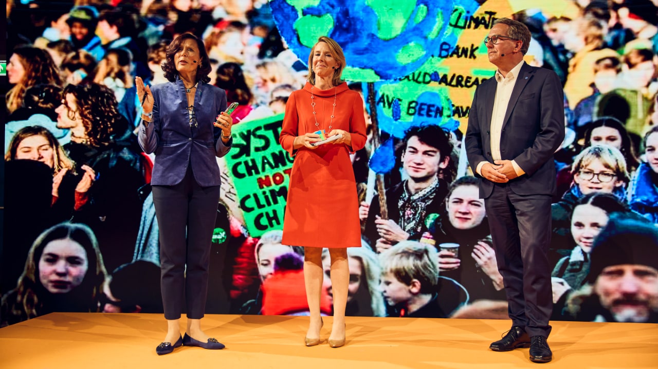 Sandrine Dixson-Declève (Club of Rome), Stientje van Veldhoven (World Resources Institute WRI) and Martin Frick (World Food Programme WFP) speak at the DLD Nature conference, standing in front of a colorful background.