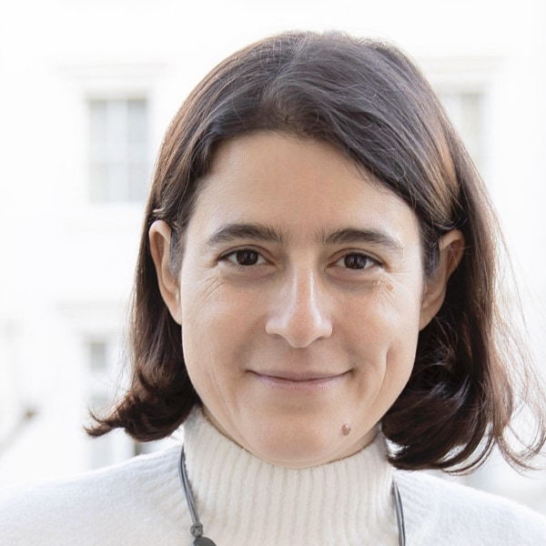 Close-up portrait of Christina Nesheva, Chair of the Board of Officinae Bio, smiling a the camera.