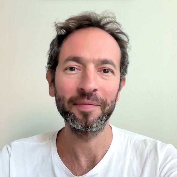 Headshot of Edward Shenderovich, CEO of Synonym, in front of a white wall.