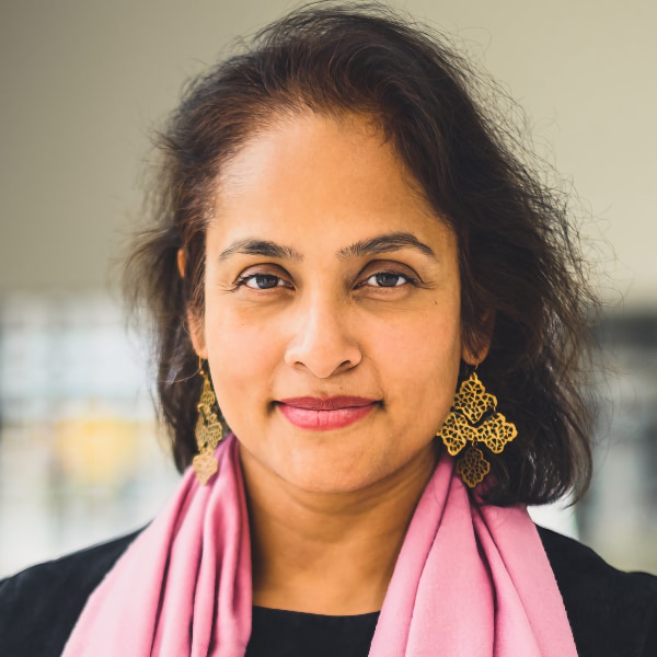 Portrait photo of Dutch cybersecurity expert Jaya Baloo, looking at the camera, wearing a colorful pink scarf.