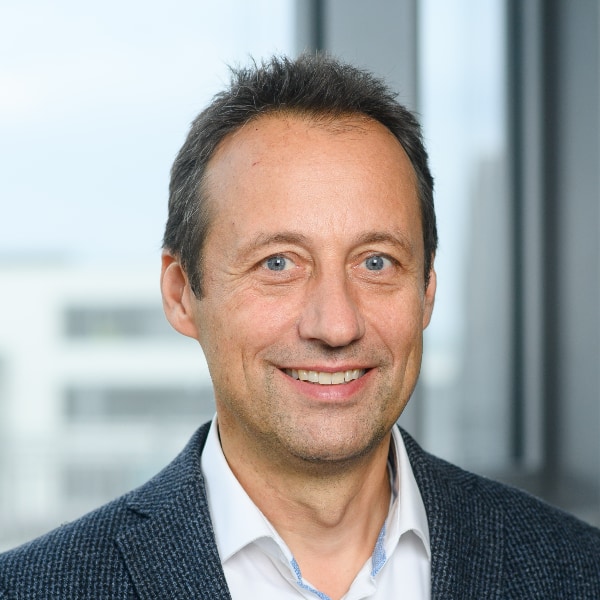 Portrait image of Prof. Markus Lienkamp, automotive expert at Technical University Munich, seen in his office, smiling at the camera.