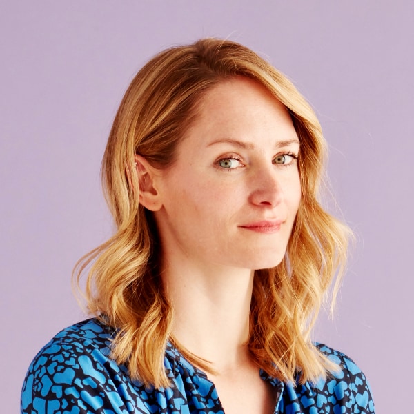 Studio portrait image of journalist Sophie Schmidt, founder of Rest of World, looking over her shoulder to the camera.