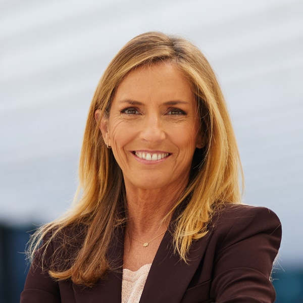 Outdoor portrait of Portugese energy executive Vera Pinto Pereira, board member of EDP group, smiling at the camera.