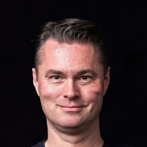 Studio portrait of Andreas Hufenstuhl, AI and data analytics expert at PwC Germany, in front of a dark background.