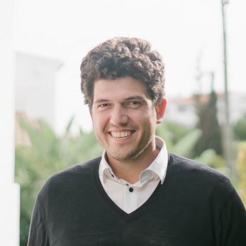 TUM Venture Labs manager Bastian Burger, seen outdoors, smiling at the camera.