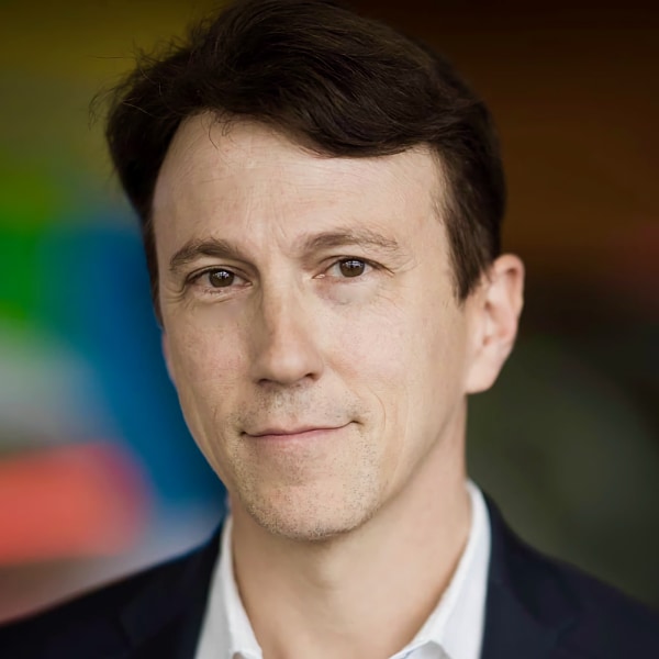 Headshot portrait image of biomedicine expert Daniel Kraft, founder of NextMed Health, smiling at the camera.