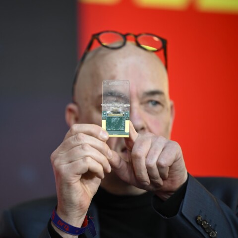 Journalist Andrian Kreye holds up an organoid chip by Swiss company FinalSpark for the audience to see.