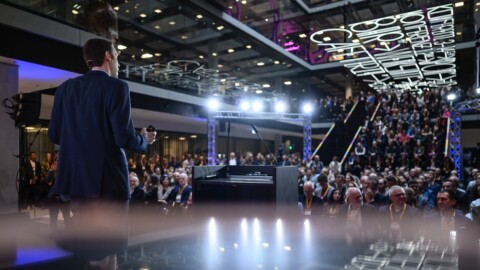 AI researcher Björn Ommer of LMU Munich on stage during his DLD Munich 2025 talk, seen from behind facing the audience.