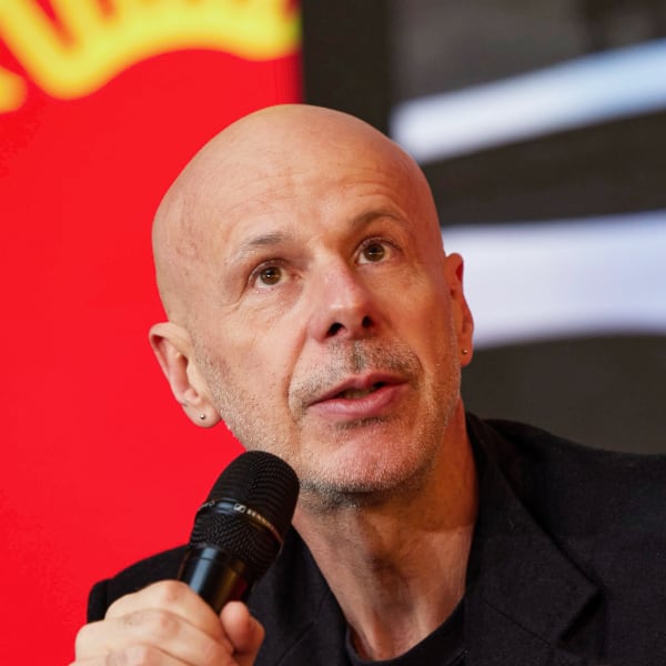 Portrait of French artist Philippe Parreno, holding a microphone, as he speaks at the DLD Munich conference.