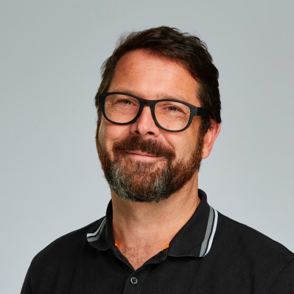 Studio headshot portrait of Alexander Pretschner, professor at TU Munich, in front of a neutral grey background.