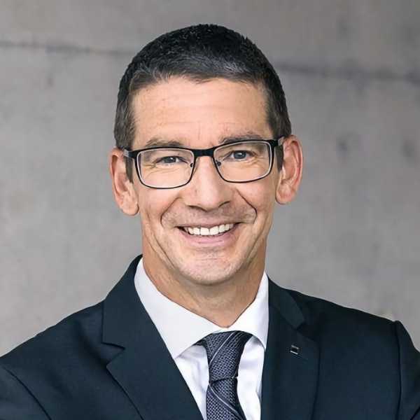 Headshot portrait of Dr. Hagen Zimer, board member of TRUMPF SE, wearing a suit and tie, smiling at the camera.