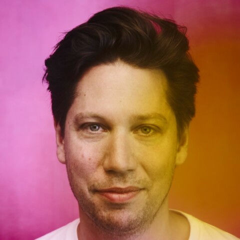 Colorful headshot portrait of social entrepreneur Florian Hoffmann, CEO and founder of The DO, looking at the camera, smiling, with gradient filter applied.
