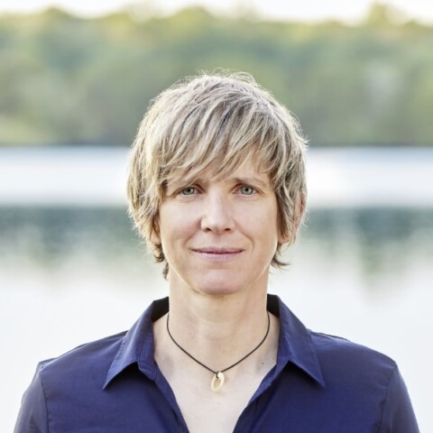 Portrait of ecologist Dr. Katrin Schuhen, Founder & CEO of Wasser 3.0, seen outdoors in front of a lake.