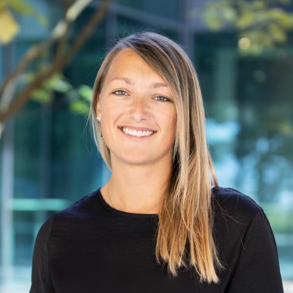 Headshot portrait of robotics engineer Annette Hagengruber, outside, with trees visible in the background.