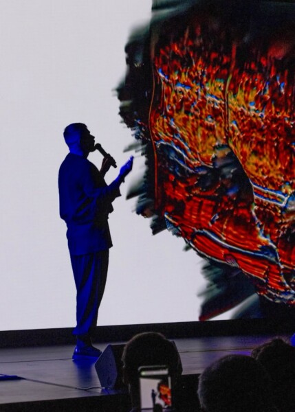 Grammy Award-winning new media artist Harry Yeff giving a performance at the DLD Future Hub conference, interacting with a colorful data cloud.