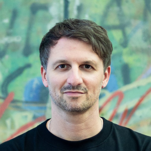 Headshot portrait of Lutz Leichsenring, VibeLabs, in front of a colorful background.