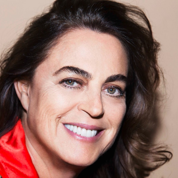 Tightly cropped close-up portrait of Maja Hoffmann, founder of the Luma Foundation, in front of a beige studio background.