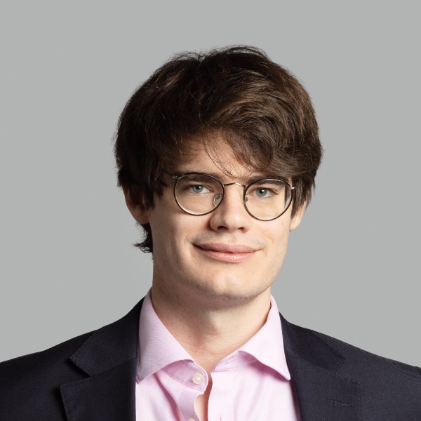 Studio headshot portrait of Keegan McBride (Tony Blair Institute for Global Change) in front of a neutral grey background.