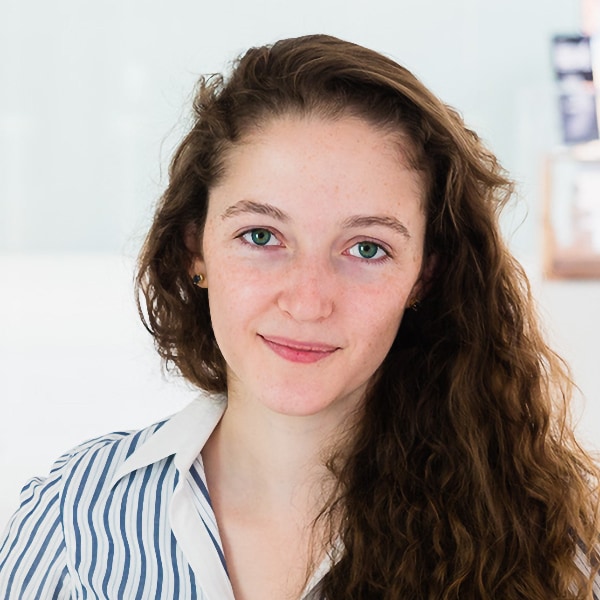 Environmental portrait of space exploration expert Ariel Ekblaw, Aurelia Institute and Aurelia Foundry, in front of a bright blue background.