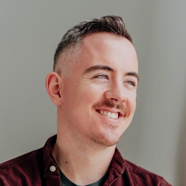 Headshot portrait of cybersecurity expert Donncha Ó Cearbhaill, Amnesty International, looking outside the frame to the right, smiling.