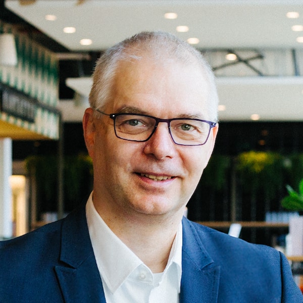 Environmental portrait of Dr. Wieland Holfelder, Google, seen in an office environment, smiling at the camera.