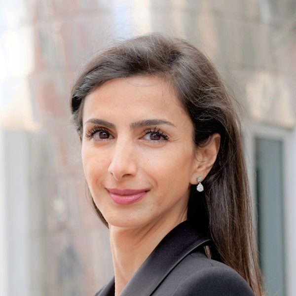 Environmental portrait of legal expert Anahita Thoms, Baker McKenzie, outdoors, smiling at the camera.
