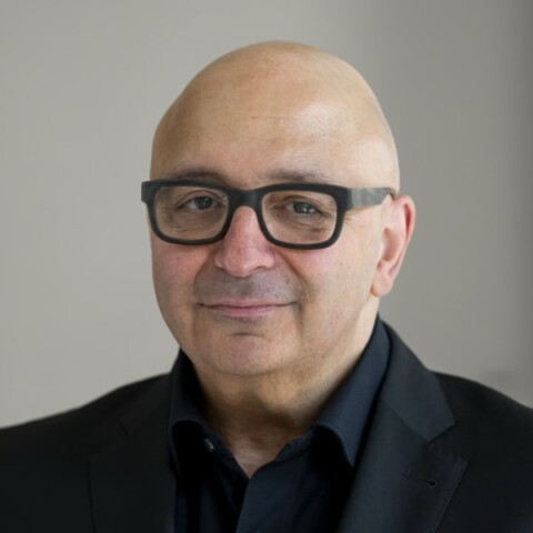 Headshot portrait of sociologist Armin Nassehi, LMU, in front of a grey studio background.