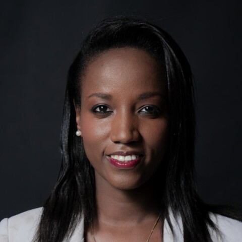 Headshot portrait of human rights activist Carine Kanimba, World Liberty Congress, in front of a dark studio background.