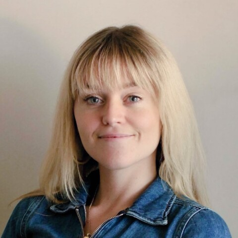 Headshot portrait of social entrepreneur Christabel Reed in front of a grey wall.