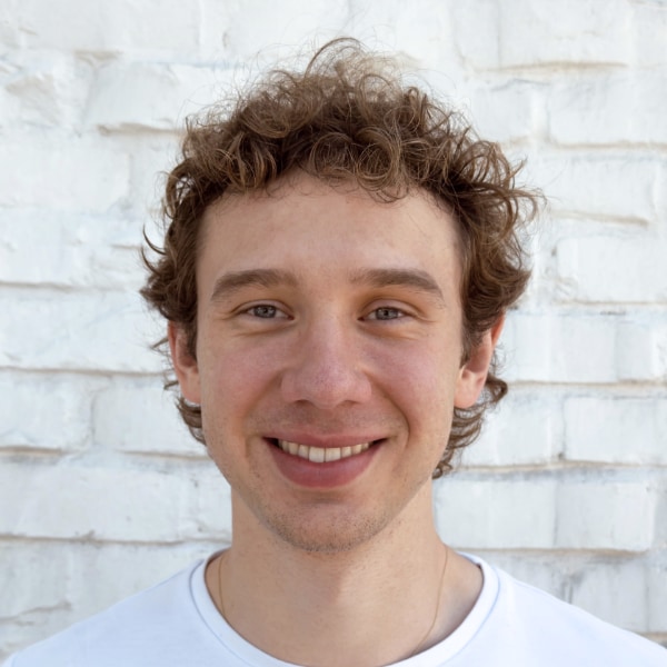 Portrait of Attention Engineering co-founder Julian Windeck in front of a white brick wall.