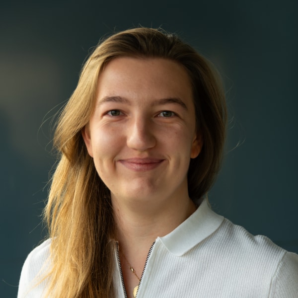 Studio portrait of PAVE Space founder Julie Böning, brightly lit in front of a dark background.