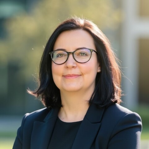 Outdoor portrait of Karin Immenroth, Mediaplus Group, in a sunny, green environment.