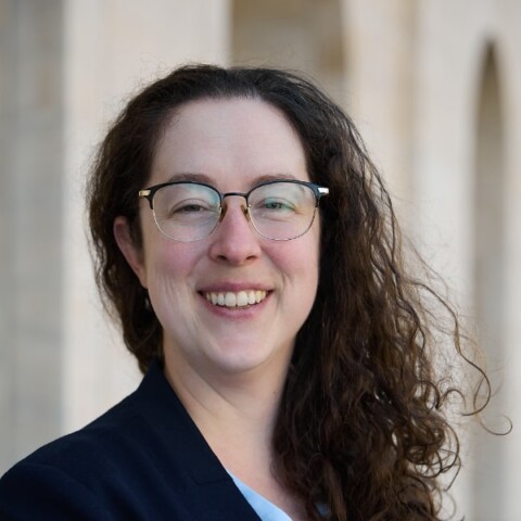 Environmental portrait of AI ethics expert Dr. Keri Grieman, University of Oxford, in front of a light grey background.