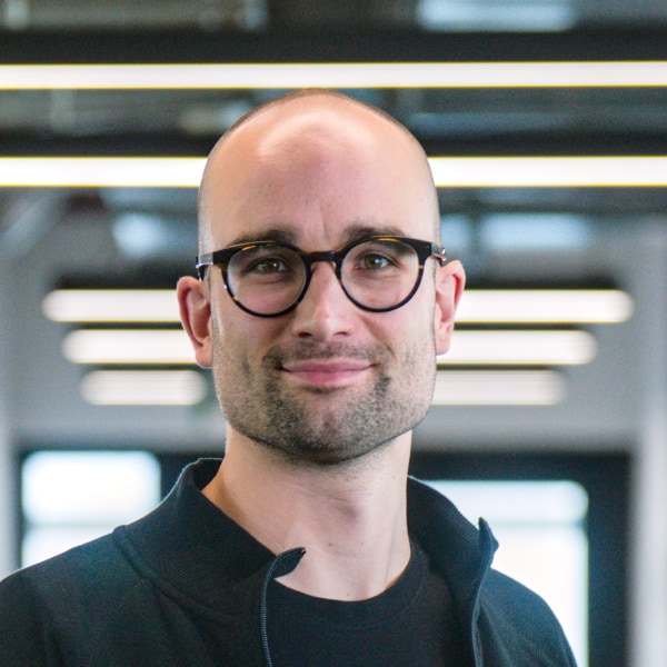 Headshot portrait of QuantumDiamonds CEO Kevin Berghoff, seen in an office environment under neon lights.