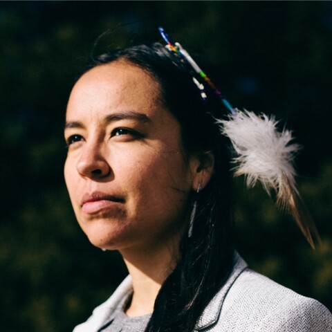 Portrait of Indigenous musician and author Lyla June Johnston, looking left outside the frame.