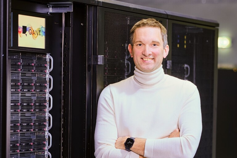 Michael F&ouml;rtsch, founder and CEO of photonic processing company Q.ANT, standing in front of a data center server rack.